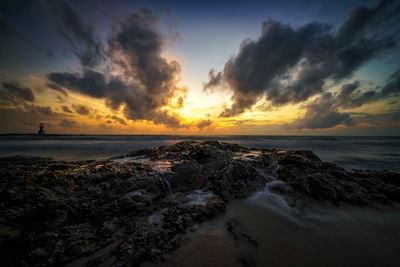 View of calm beach at sunset