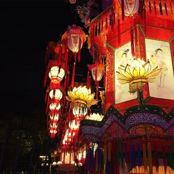 Low angle view of illuminated lanterns hanging against sky at night