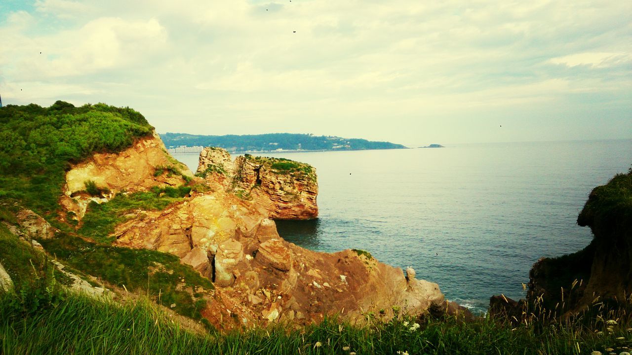 sea, tranquil scene, tranquility, scenics, water, sky, horizon over water, beauty in nature, rock formation, cliff, nature, rock - object, rock, idyllic, cloud - sky, coastline, beach, non-urban scene, landscape, cloud