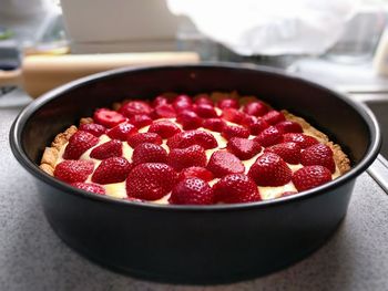 Cake with strawberries in bowl on table at home