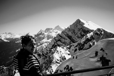 Man standing on snowcapped mountain against sky