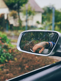 Reflection of man on side-view mirror