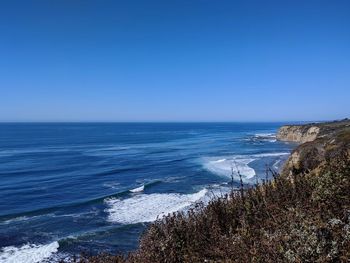 Scenic view of sea against clear blue sky