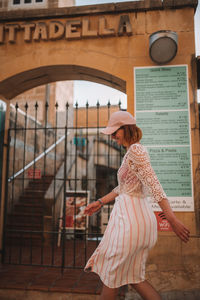 Rear view of woman standing against the wall