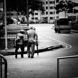 Rear view of friends walking on city street