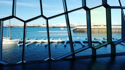 Close-up of sea against sky seen through railing