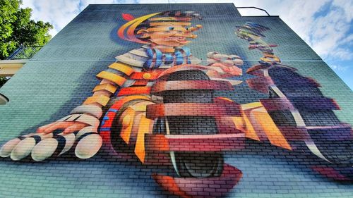 Low angle view of woman sitting against sky