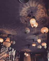 Low angle view of illuminated chandelier hanging on ceiling