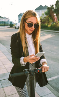 Woman using mobile phone in city