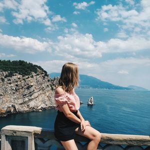 Rear view of woman looking at sea against sky