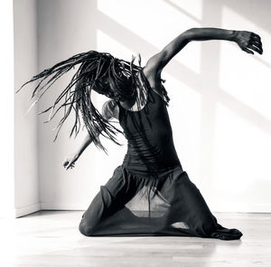 Woman with dreadlocks dancing at home