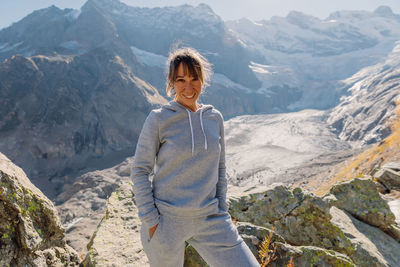 Portrait of young woman standing against mountain