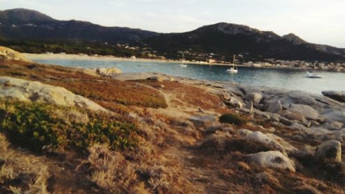 Scenic view of sea and mountains against sky