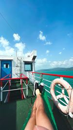 Low section of man on boat against sky