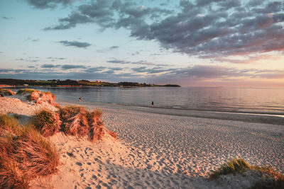 Scenic view of beach against sky during sunset