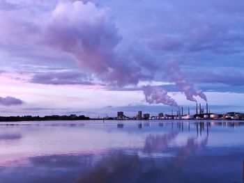 Smoke emitting from factory against sky at dusk