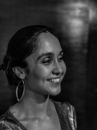 Close-up of smiling woman looking away in darkroom