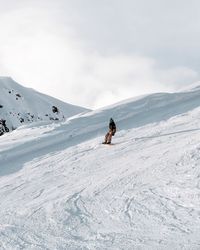 People on snowcapped mountain against sky