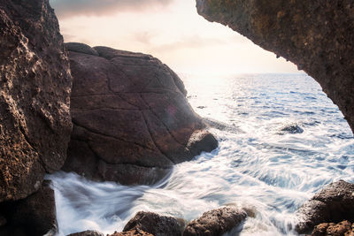 Scenic view of rocks in sea against sky