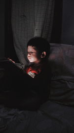 Boy sitting on bed at home