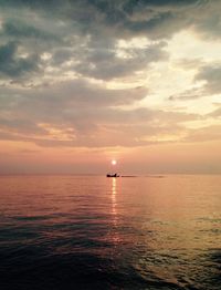 Boats in sea at sunset