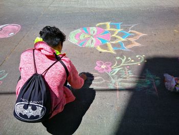 Rear view of woman standing against multi colored umbrella