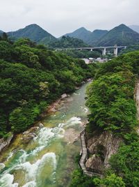 High angle view of river amidst trees against sky