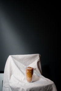 Close-up of hand holding drink against black background