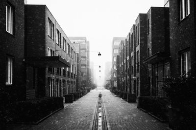 Street amidst buildings in town against sky