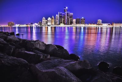 Illuminated skyline by detroit river at night