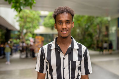 Portrait of teenage boy standing in city