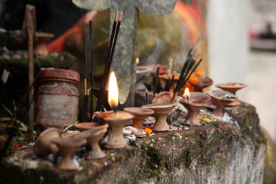 Close-up of diyas burning in temple