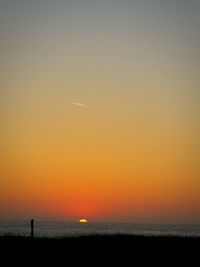 Scenic view of sea against orange sky