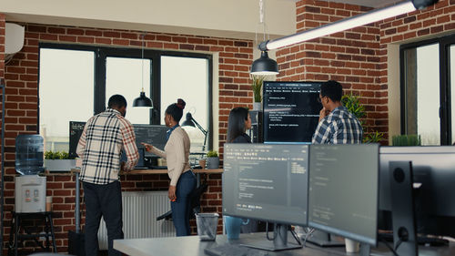 Rear view of computer programmers working at office