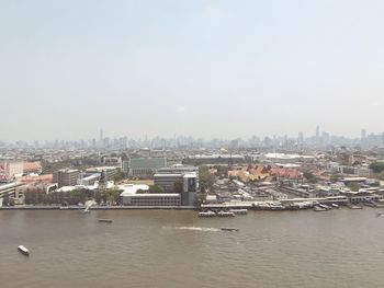 River by cityscape against sky