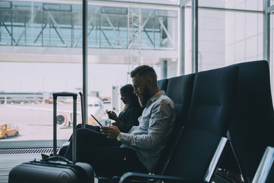 People looking at camera while sitting in airport