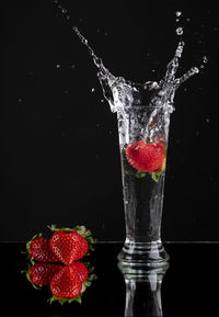 Red berries on water against black background