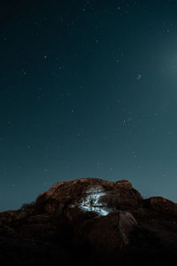 Low angle view of rock formation against sky at night