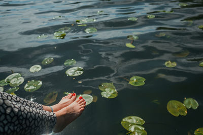 Low section of woman floating on lake
