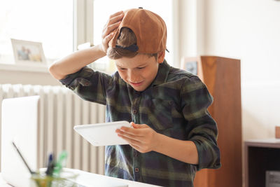 Boy holding mobile phone at home