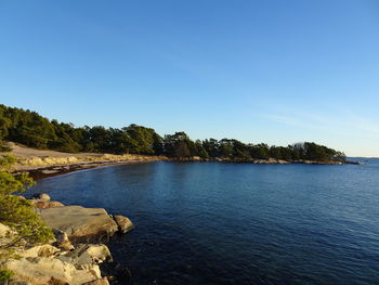 Scenic view of lake against clear blue sky