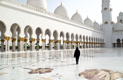 Rear view of woman walking outside historic mosque