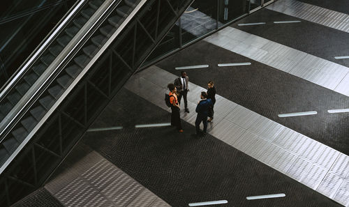 High angle view of male entrepreneurs discussing with female colleagues in meeting on walkway