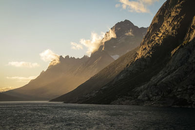 Scenic view of sea and mountains against sky during sunset