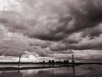 Scenic view of river against cloudy sky