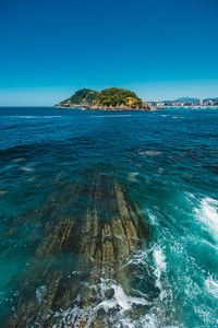 Scenic view of sea against clear blue sky