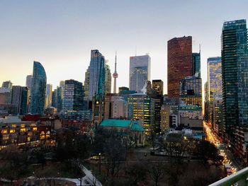 Illuminated buildings in city against sky