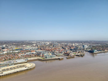 High angle view of buildings by sea against clear sky