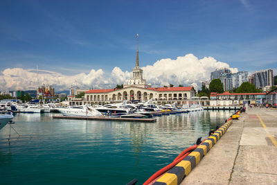 View of boats in city against cloudy sky