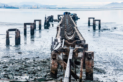 Pier over sea against sky during winter